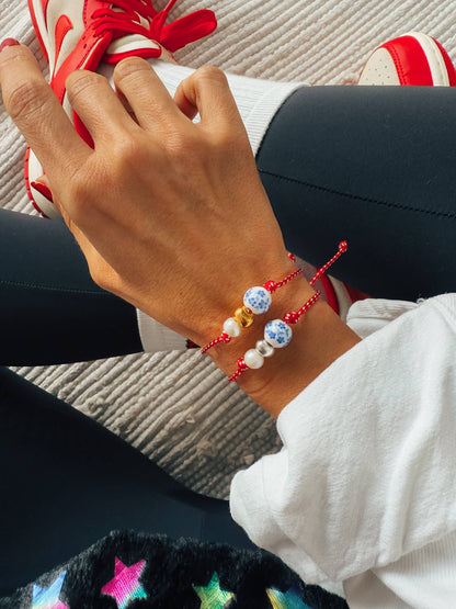 Spring bracelet with red cord porcelain bead and pearl: Yellow Gold
