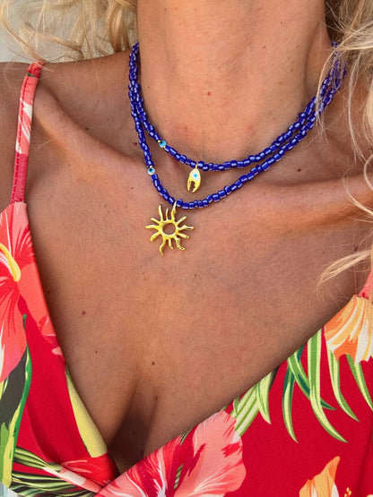 Blue beaded necklaces with gold sea charm: Crab claw necklace