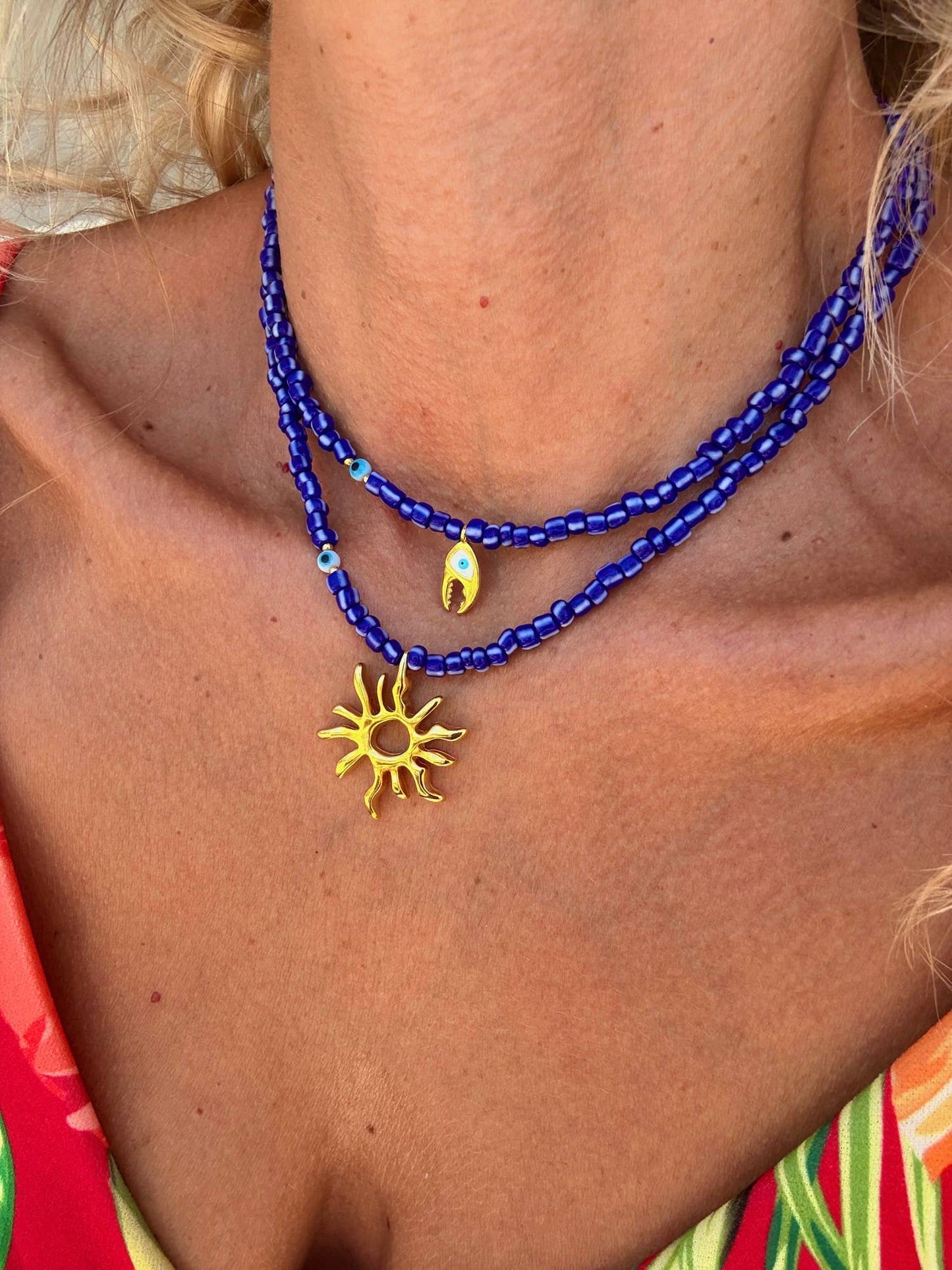 Blue beaded necklaces with gold sea charm: Crab claw necklace